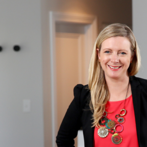 Photo of kirryn in orange top and black jacket smiling
