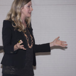 Kirryn Zerna presenting on stage with hands out