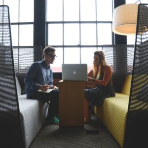 A man and a woman looking at a computer