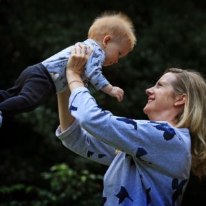 Photo of Kirryn holding her baby, Bailey in the air