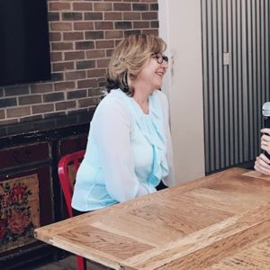 Kirryn and friend sitting talking at a wooden table