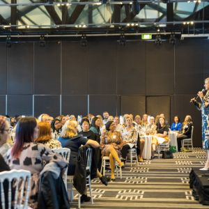 Kirryn standing on stage speaking to audience
